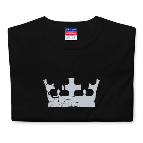 Folded black heavyweight, 100% cotton luxury Champion© t-shirt featuring aged crown emblem and text "EST. 2007" indicating the year the faction was first introduced to the brick universe. Item is a BRKDrip Heritage Collection luxury shirt with a vintage castle building block aesthetic.