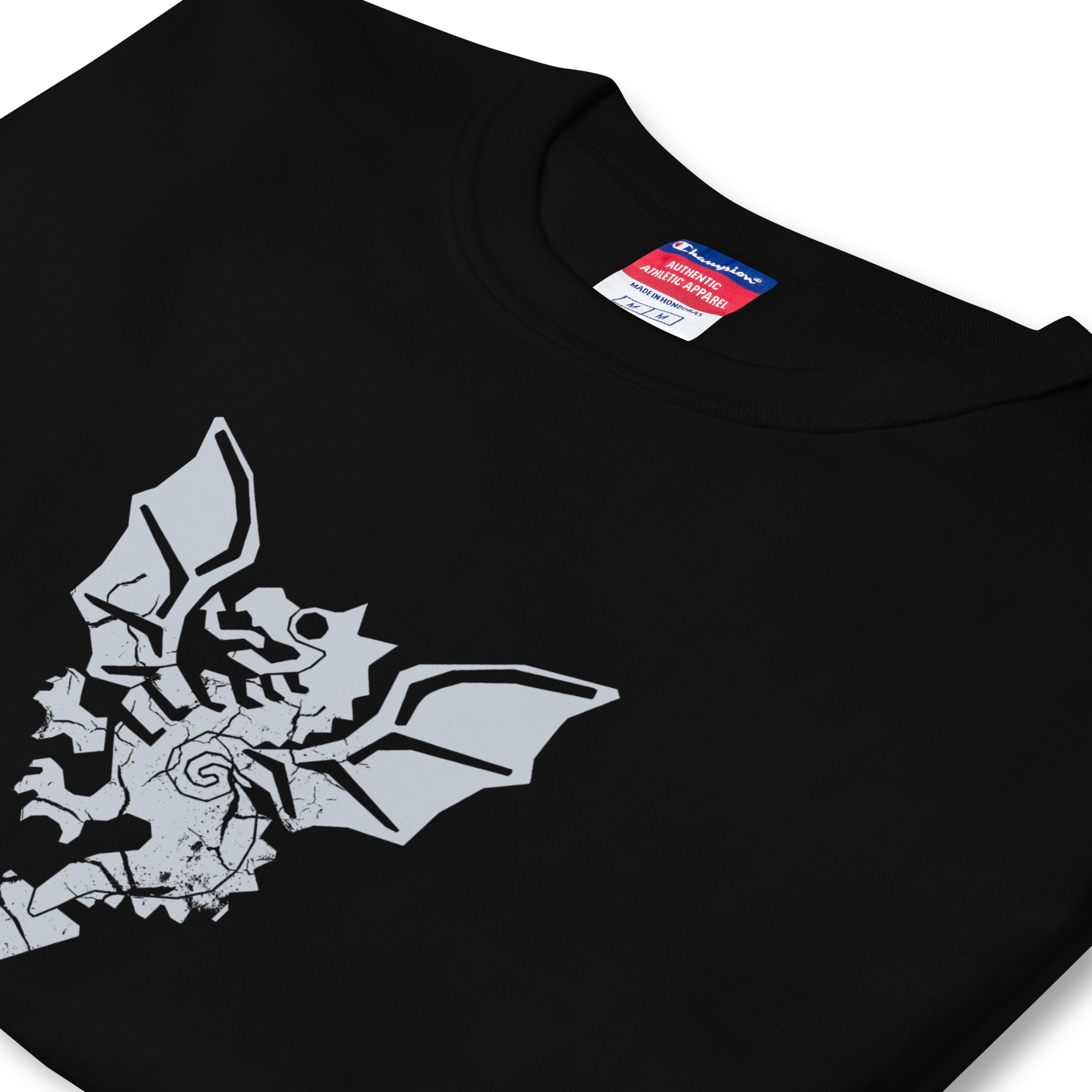 Folded side profile of black heavyweight, 100% cotton luxury Champion© t-shirt featuring aged dragon masters emblem and text "EST. 1988" indicating the year the faction was first introduced to the brick universe. Item is a BRKDrip Heritage Collection luxury shirt with a vintage castle building block aesthetic.