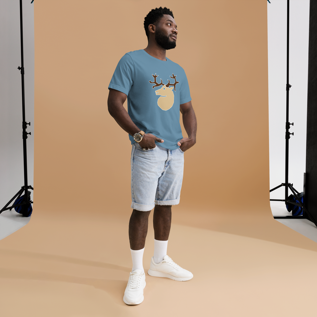 Fashionable male model against brightly lit orange background wearing a steel blue 100% airlume cotton t-shirt featuring classic fan-made woodland outlaws deer / stag crest design. Item is a BRKDrip AFOL essentials shirt with a vintage castle building blocks aesthetic. 