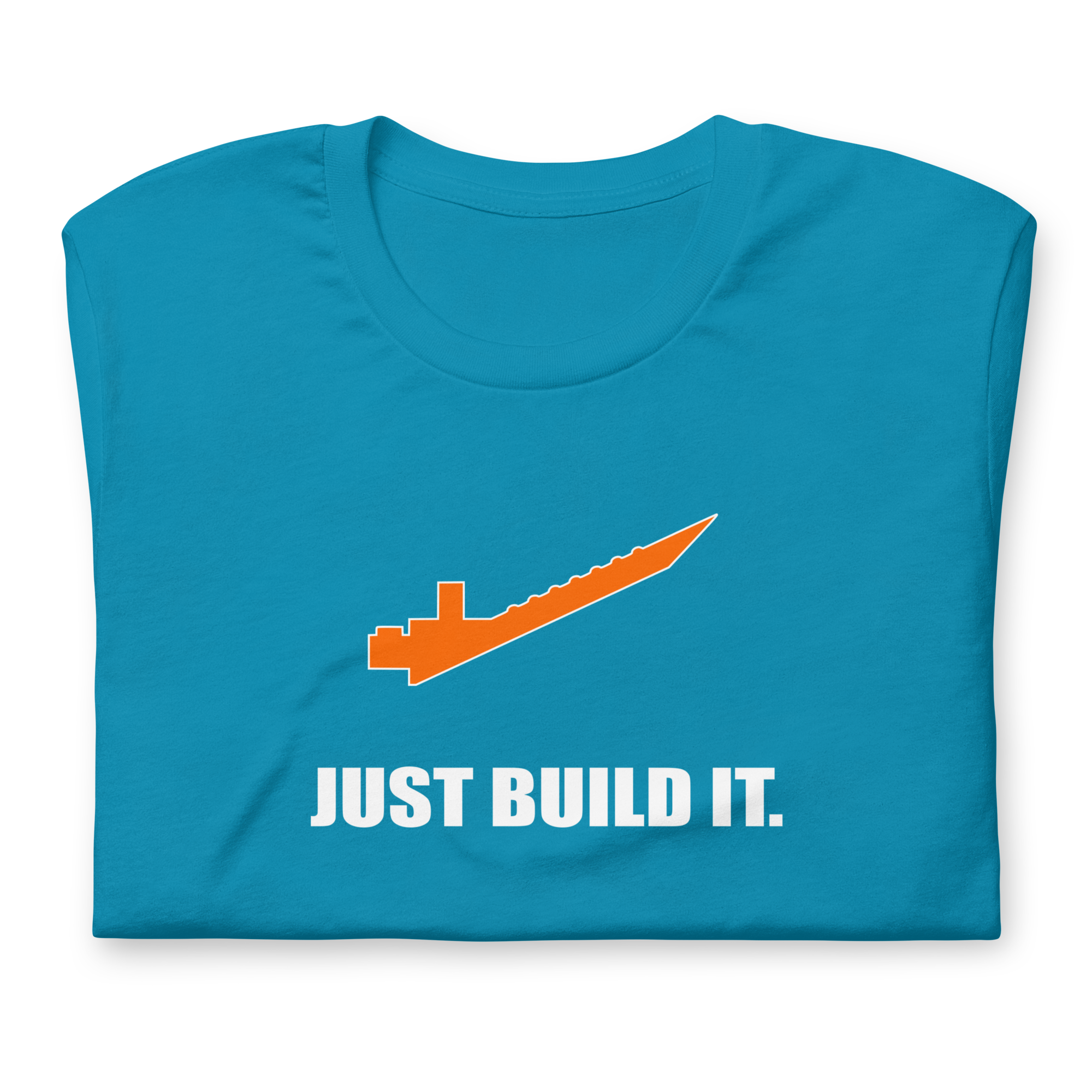Folded aqua blue 100% airlume cotton t-shirt featuring orange brick separator and parody AFOL saying: "Just Build It". Item is a BRKDrip AFOL essentials shirt with a modern brick-inspired aesthetic.