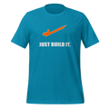Aqua blue 100% airlume cotton t-shirt featuring orange brick separator and parody AFOL saying: "Just Build It". Item is a BRKDrip AFOL essentials shirt with a modern brick-inspired aesthetic.
