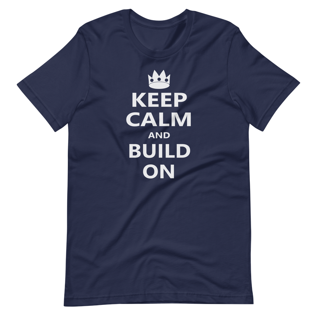 Wrinkled navy blue 100% airlume cotton t-shirt featuring OG castle crown and parody AFOL saying: "Keep Calm and Build On". Item is a BRKDrip AFOL essentials shirt with a modern brick-inspired aesthetic.
