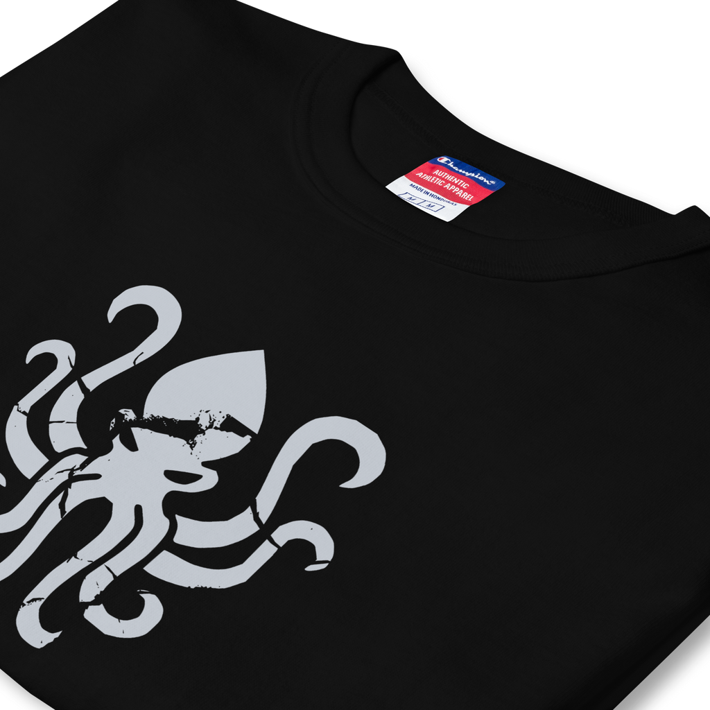 Folded side profile of black heavyweight, 100% cotton luxury Champion© t-shirt featuring aged terrifying kraken sea monster emblem and text "EST. 2020" indicating the year the faction was first introduced to the brick universe. Item is a BRKDrip Heritage Collection luxury shirt with a vintage castle building block aesthetic.