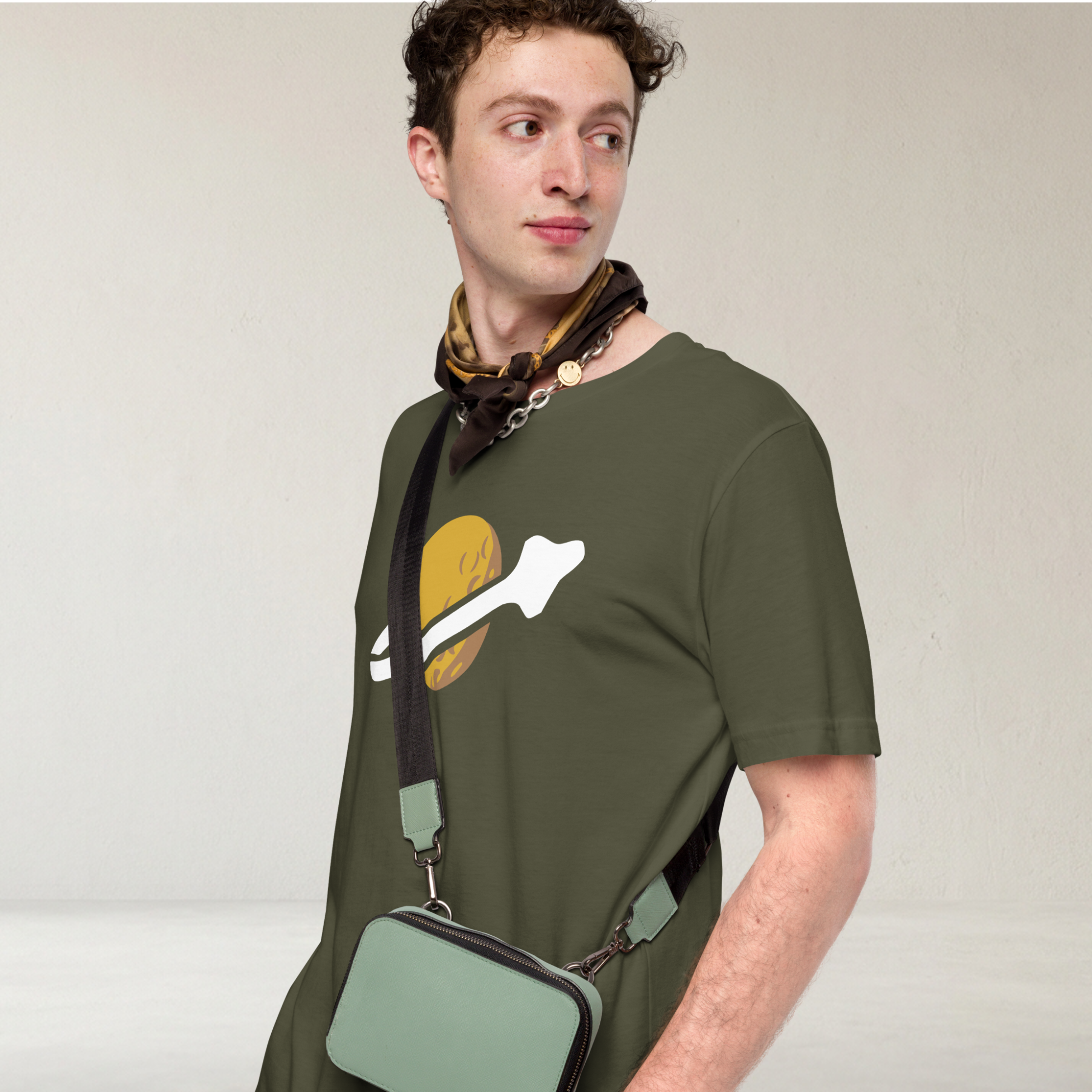 Fashionable male model wearing olive green 100% airlume cotton t-shirt featuring classic fan-made OG yellow planet with spaceship classic space logo design. Item is a BRKDrip AFOL essentials shirt with a vintage space building blocks aesthetic.