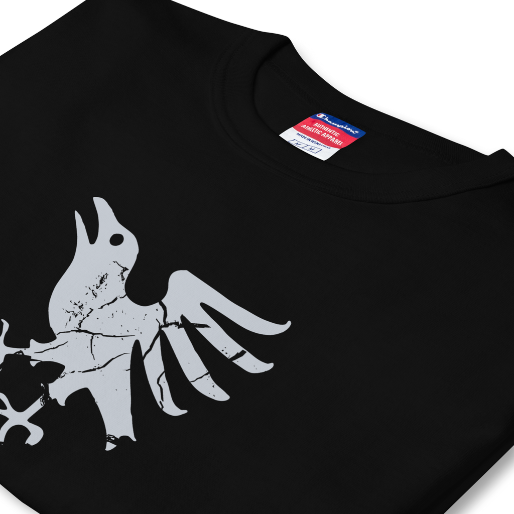 Folded side profile of black heavyweight, 100% cotton luxury Champion© t-shirt featuring aged raven emblem and text "EST. 2020" indicating the year the faction was first introduced to the brick universe. Item is a BRKDrip Heritage Collection luxury shirt with a vintage castle building block aesthetic.