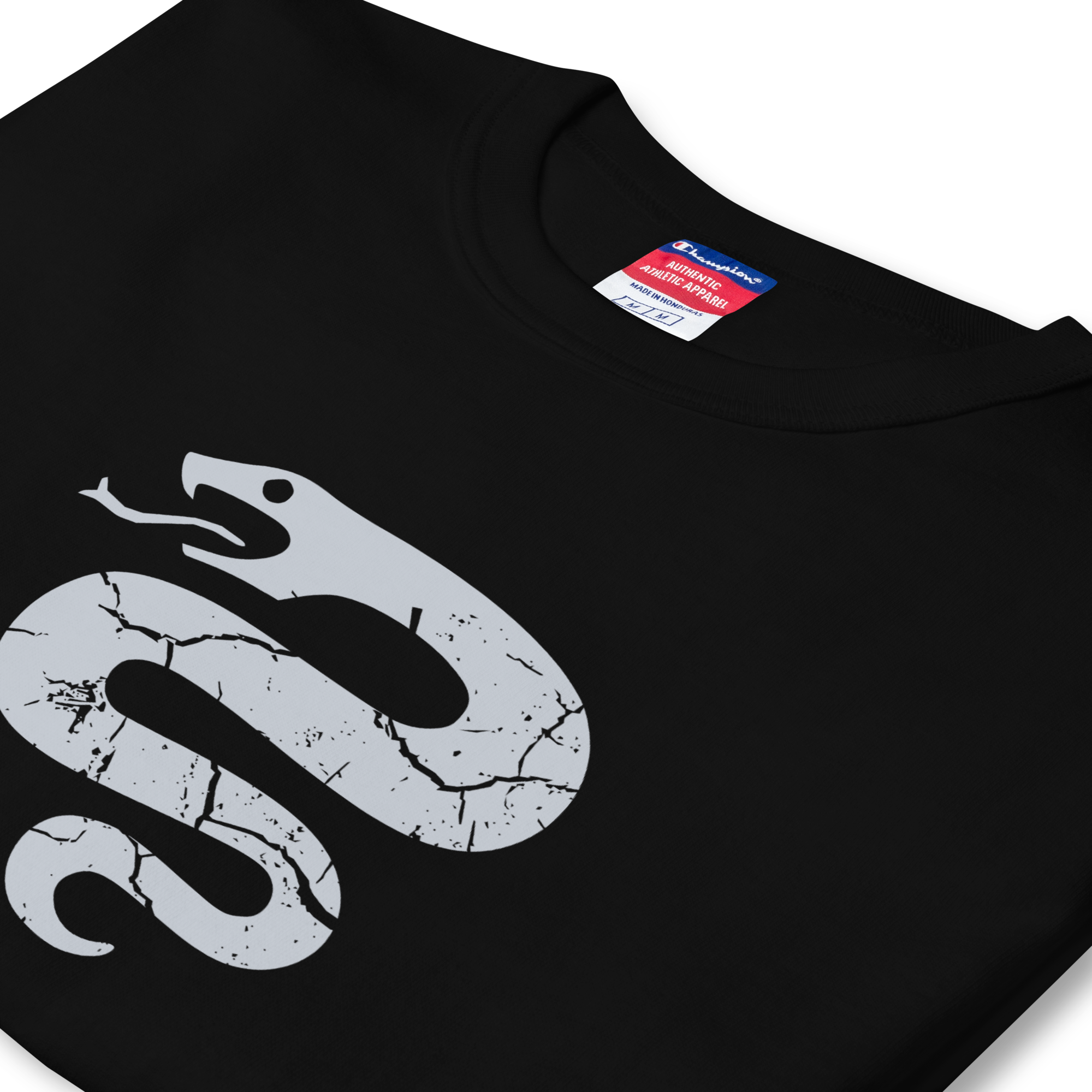 Folded side profile of black heavyweight, 100% cotton luxury Champion© t-shirt featuring aged serpent emblem and text "EST. 2025" indicating the year the faction was first introduced to the brick universe. Item is a BRKDrip Heritage Collection luxury shirt with a vintage castle building block aesthetic.