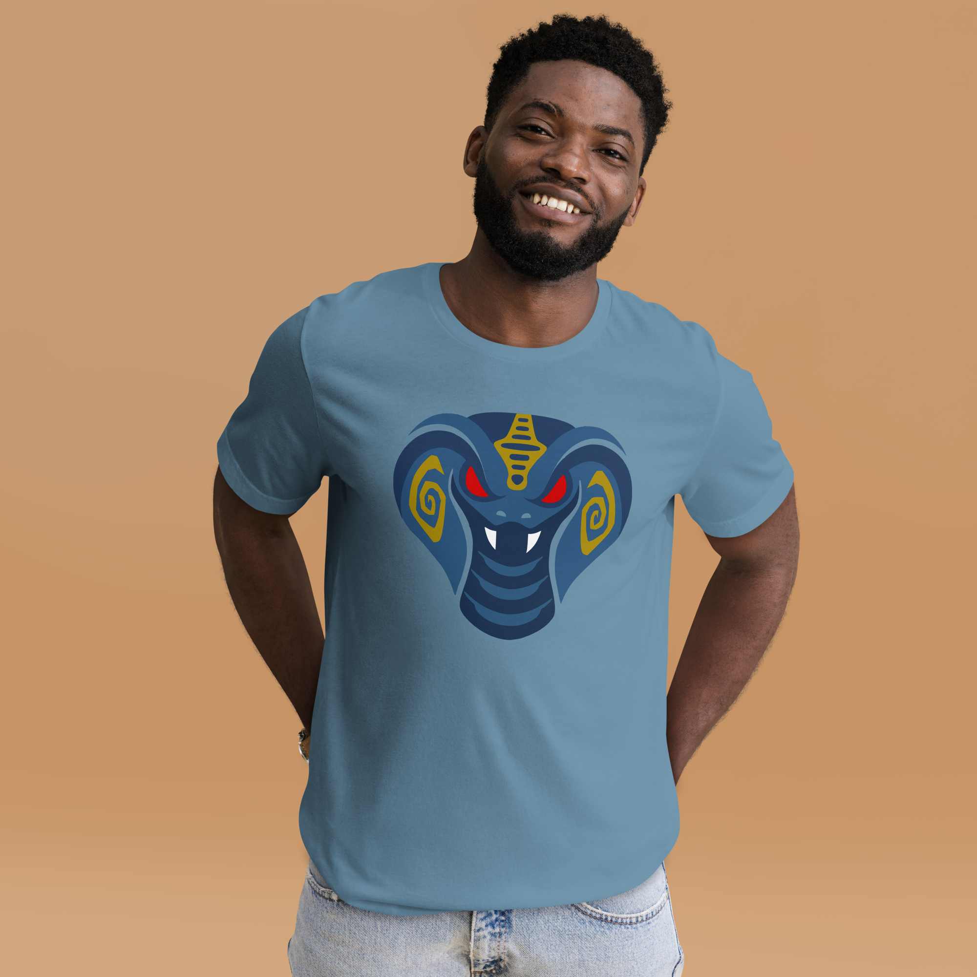 Fashionable male model against orange background wear steel blue 100% airlume cotton t-shirt featuring fan-made cult-classic scaley snake king design. Item is a BRKDrip AFOL essentials shirt with a modern elemental brick masters aesthetic.